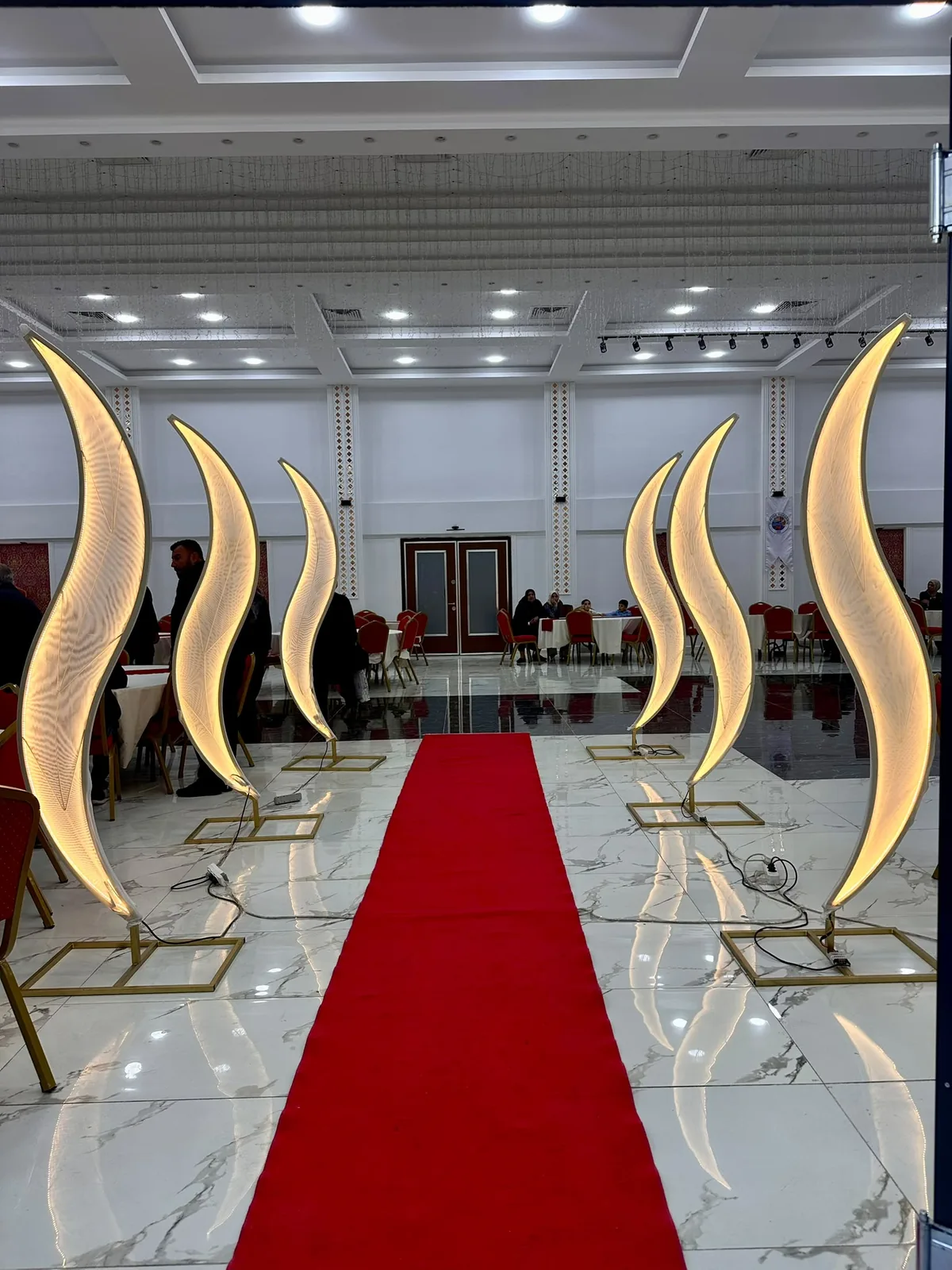Davet salonunda gold formlar ve kırmızı halıyla tasarlanan giriş