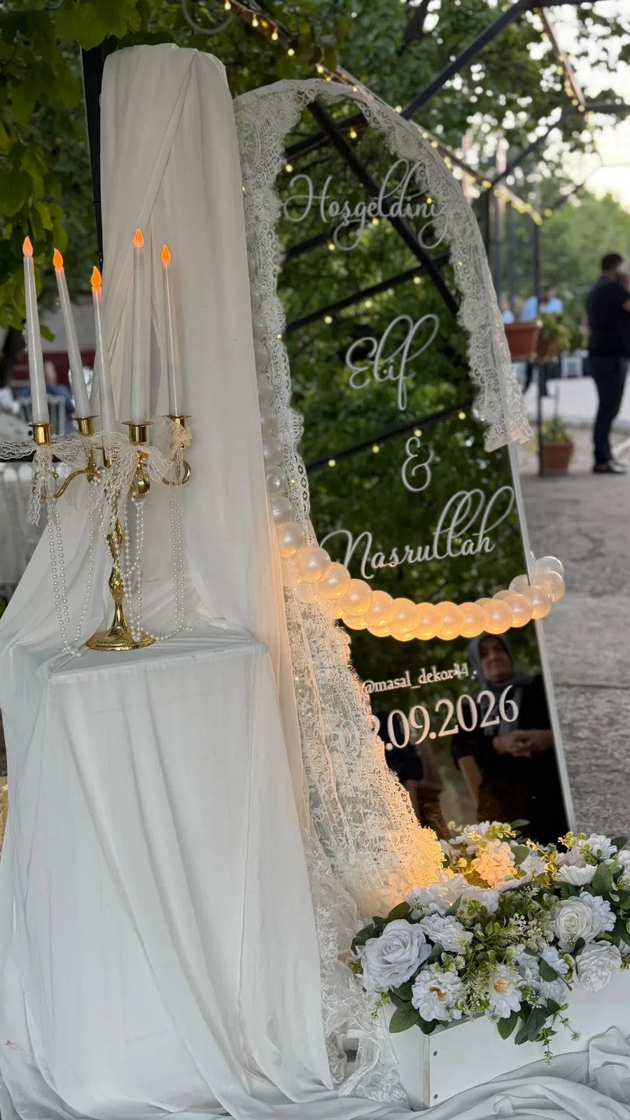 Beyaz tüller ve çiçeklerle süslenmiş bahçe dekoru