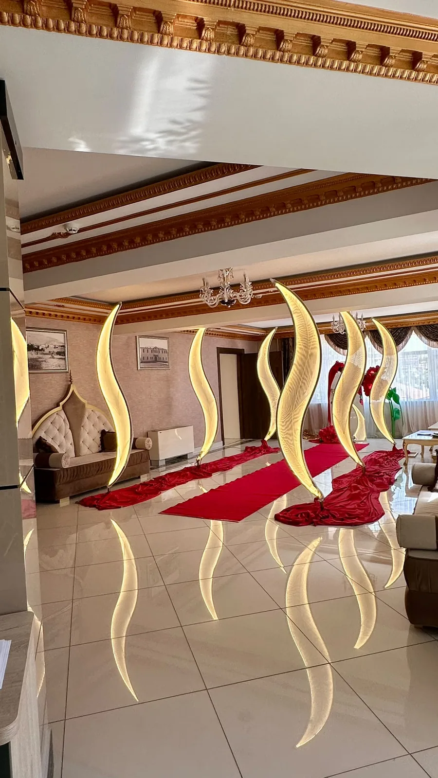 Davet salonunda kıvrımlı gold dekorlar ve kırmızı halı